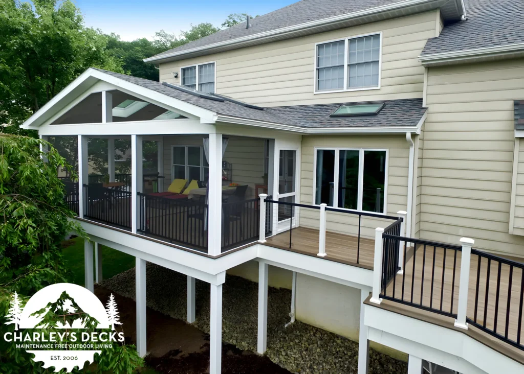 Charley’s Decks covered porch with white roof framing, black railings and an elevated deck walkway