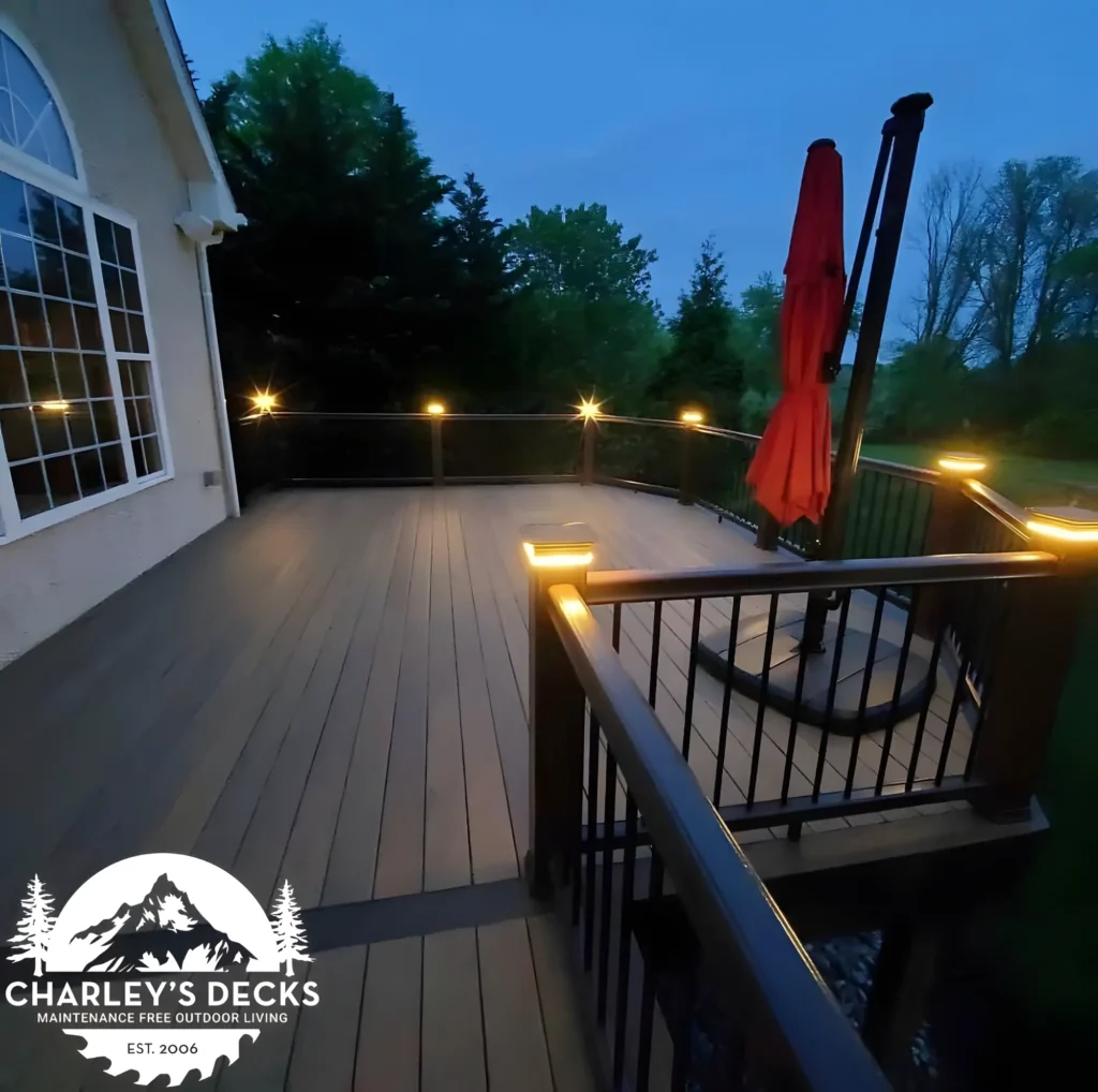 Composite deck at dusk with dark railings and illuminated post caps